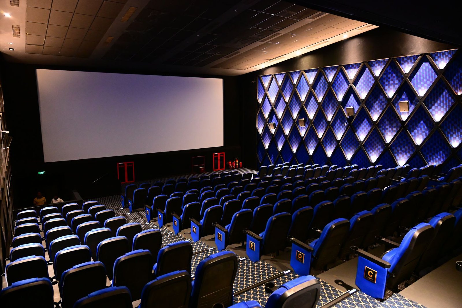 A Cineverse Multiplex auditorium with an illuminated diamond feature wall